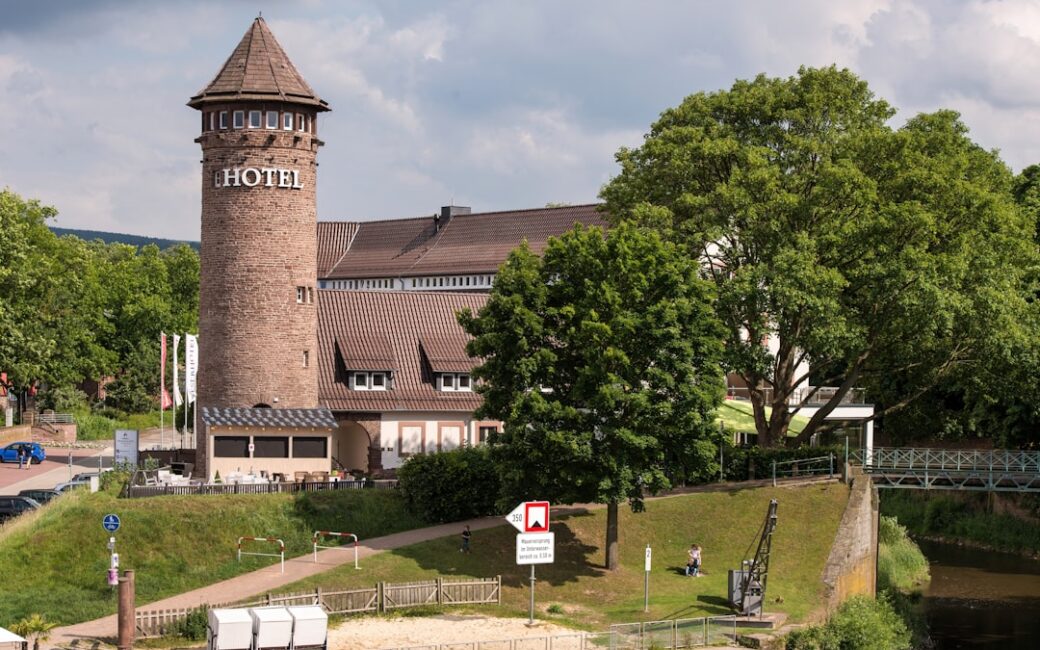 Historic tower building with "hotel" sign near water.